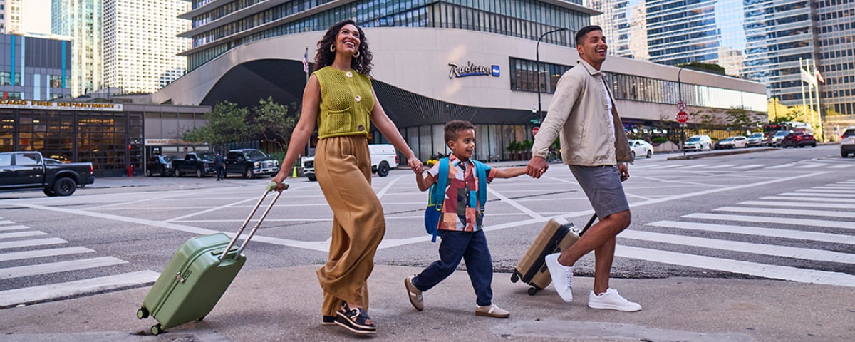 A family crossing the street in front of Radisson hotel - Buy Points